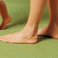 Nackte Füße auf grünem Teppichboden